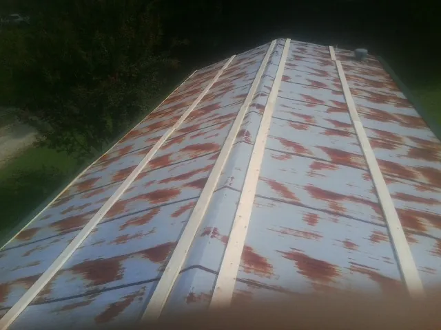 Rusted metal roof panels with new wood purlins before replacement — Storm Damage Roof Repair in Canastota by Roofing Brothers